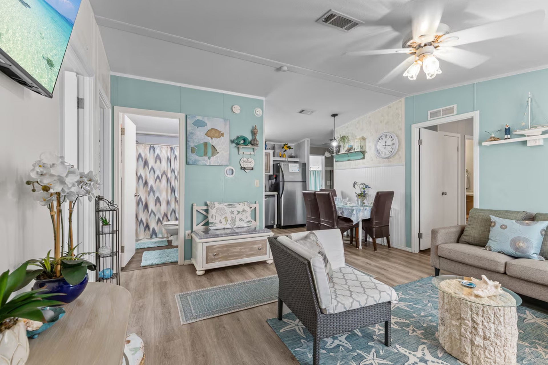 Open living room with sofa, television, and dining view